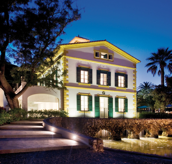 Lush green fields and farm buildings at Agroturism Ca Na Xini, inviting guests to enjoy the rural experience.